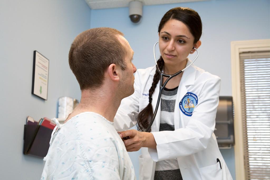 A U N E osteopathic medicine student examine a patient