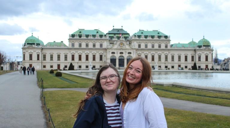 两名学生在奥地利维也纳的美景博物馆前摆姿势